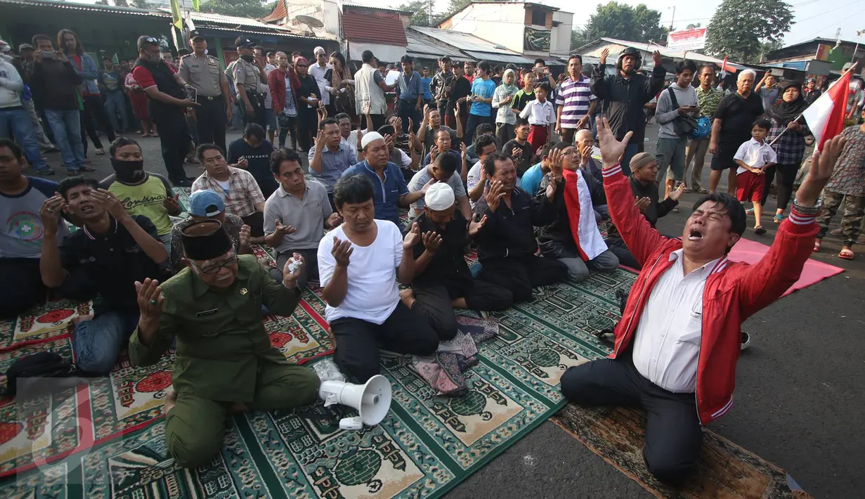 Warga melaksanakan salat duha di tengah jalan jelang eksekusi penggusuran rumah di kawasan Rawajati, Pancoran, Kamis (9/1). Hal itu dilakukan warga yang berharap pembongkaran tidak jadi dilakukan Pemkot Jakarta Selatan. (Liputan6.com/Immanuel Antonius)