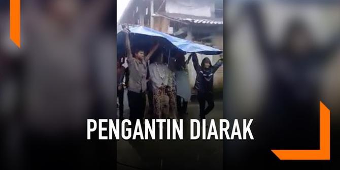 VIDEO: Hujan, Pengantin Ini Diarak Pakai Terpal