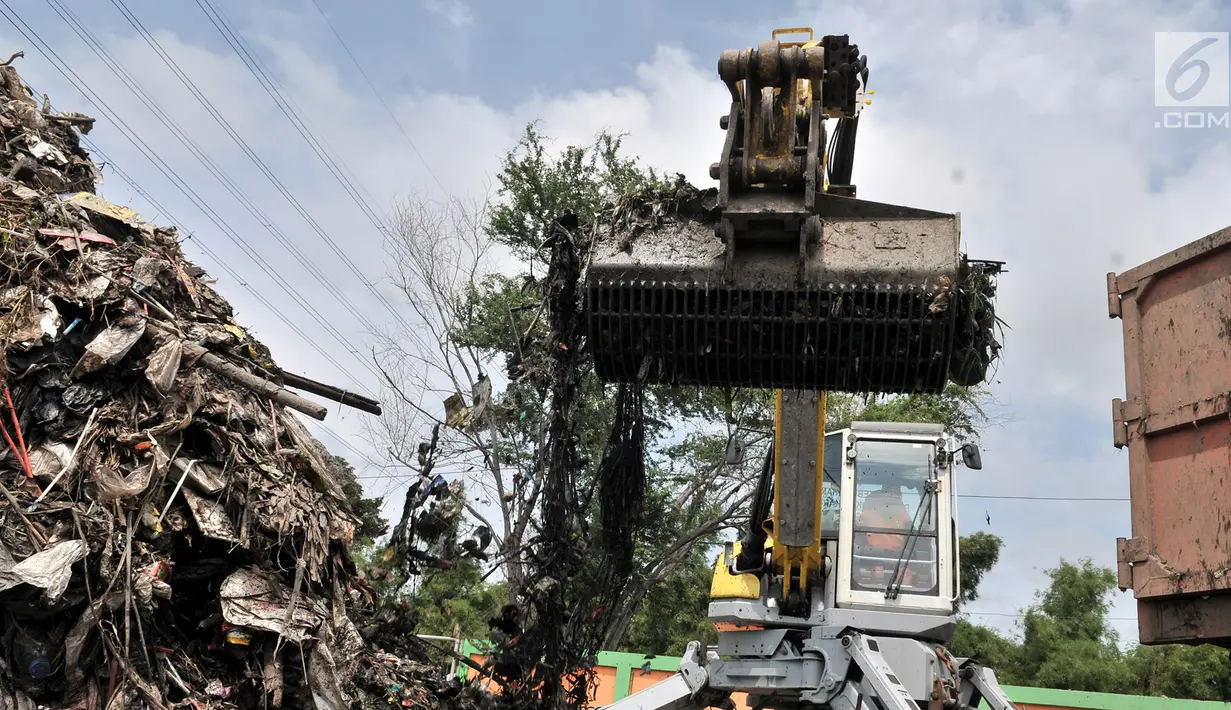 Alat berat mengangkut sampah di area proyek Fasilitas Pengolahan Sampah Terpadu atau Intermediate Treatment Facility (ITF) Sunter, Jakarta, Selasa (12/2). Proyek ITF Sunter sudah groundbreaking pada Desember 2018. (Merdeka.com/Iqbal Nugroho)