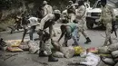 Pengemudi taksi membantu polisi menghilangkan penghalang jalan yang dibuat oleh pengunjuk rasa selama demonstrasi menuntut Perdana Menteri Haiti Ariel Henry mundur dan menyerukan kualitas hidup yang lebih baik, di Port-au-Prince, Haiti, Senin (29/8/2022). (AP Photo/Odelyn Joseph)