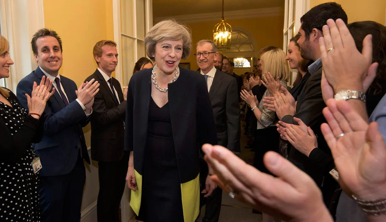  Sejumlah staf bertepuk tangan menyambut Theresa May dan suaminya Philip usai bertemu Ratu Elizabeth di 10 Downing Street, London, (13/7). Theresa May terpilih setelah pemilihan internal Partai Konservatif yang berkuasa. (REUTERS/Dominic Lipinski/Pool)