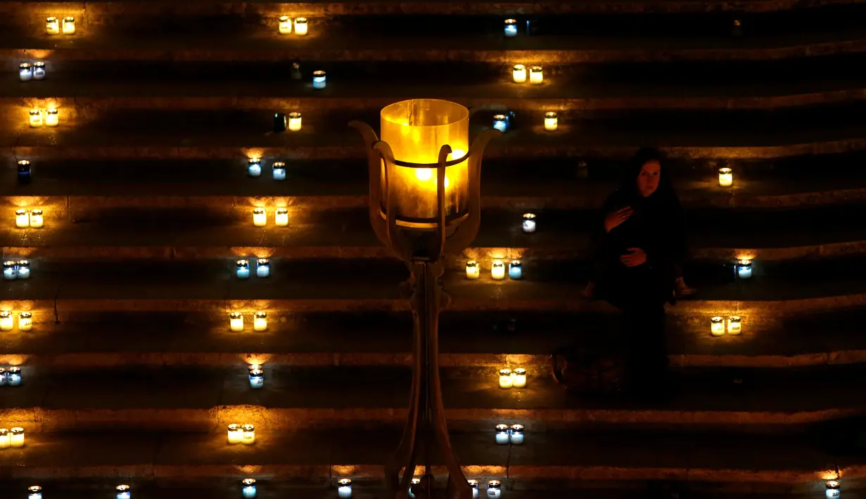 Seorang wanita menggendong anak yang sedang tidur pada Festival Cahaya Cittadella, di Benteng abad pertengahan di Victoria, Pulau Gozo, Malta, (16/3). Sekitar 30 ribu lilin bertebaran di Victoria. (REUTERS / Darrin Zammit Lupi)