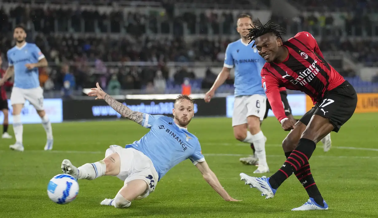 <p>Penyerang AC Milan, Rafael Leao menembak bola dari kawalan bek Lazio, Manuel Lazzari pada pertandingan lanjutan Liga Serie A Italia di Stadion Olimpiade Roma, Italia, Senin (25/4/2022). AC Milan menang tipis atas Lazio 2-1. (AP Photo/Andrew Medichini)</p>