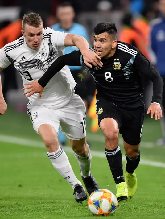 Pemain Timnas Argentina Marcos Acuna berebut bola dengan pemain Timnas Jerman Lukas Klostermann dalam laga persahabatan di Stadion Signal Iduna Park, Dortmund, Rabu (9/10/2019).  Menghadapi Argentina, Timnas Jermanharus puas bermain 2-2 dengan lawannya. (AP/Martin Meissner)