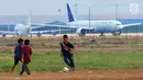 Anak-anak bermain bola di kawasan proyek perluasan landasan pacu atau Runway 3A Bandara Soekarno-Hatta (Soetta), Rawa Bokor, Tangerang, Banten, Selasa (2/7/2019). Mereka memanfaatkan lahan kosong yang belum dikerjakan pihak kontraktor untuk bermain bola. (merdeka.com/Arie Basuki)