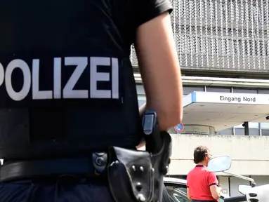 Seorang polisi berdiri di depan rumah sakit pascapenembakan di sisi barat daya ibu kota Jerman, Berlin, Selasa (26/7). Pelaku penembakan yang merupakan pasien rumah sakit itu bunuh diri setelah menembak mati seorang dokter. (Tobias Schwarz/AFP)