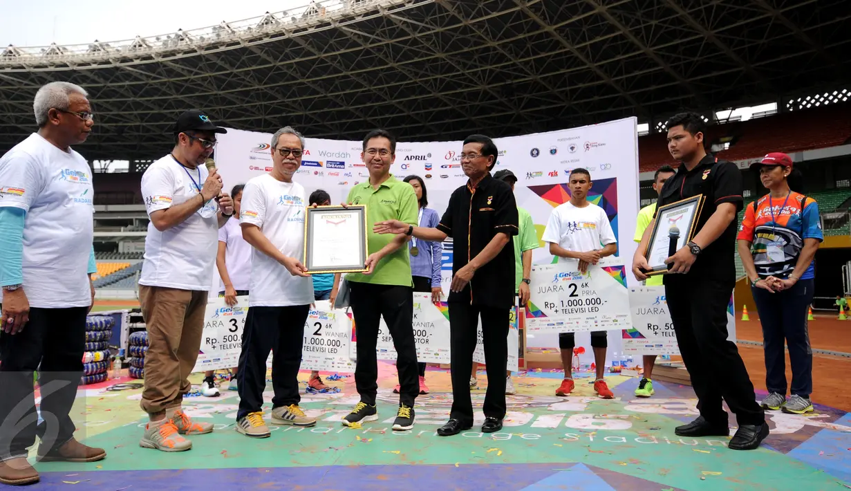 Dirut PPK GBK, Winarto (baju hijau) menerima penghargaan rekor MURI usai gelaran Gelora Run 2016 di Stadion GBK Jakarta, Minggu (22/5/2016). 2.100 pelari ambil bagian dalam ajang lari melintasi tribun Stadion GBK. (Liputan6.com/Helmi Fithriansyah)