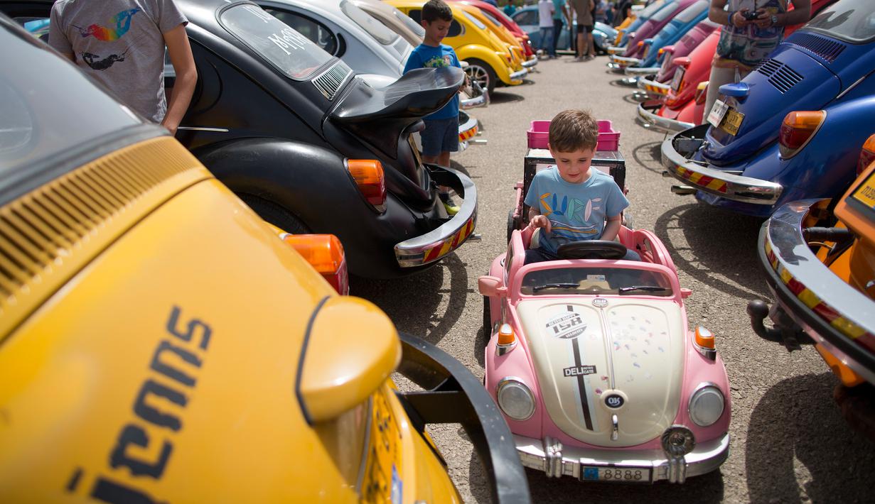 Seorang anak menaiki mobil-mobilan yang menyerupai Volkswagen Beetle dalam ajang pertemuan tahunan "Beetle club" di Yakum, Israel tengah (21/4). Di Indonesia mobil ini dikenal dengan VW Kodok. (AP Photo / Oded Balilty)