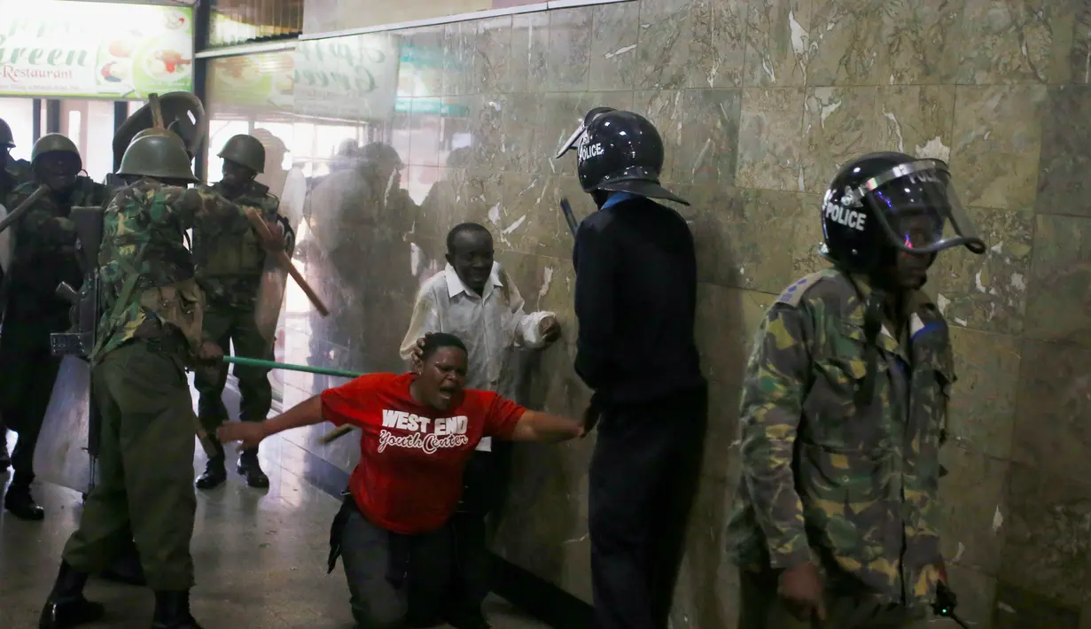Para Polisi memukuli seorang demonstran di dalam sebuah gedung saat bentrokan di Nairobi, Kenya (16/5). Demonstran menuntut pembubaran otoritas pemilu karena adanya dugaan korupsi. (REUTERS/Goran (REUTERS/Goran Tomasevic)