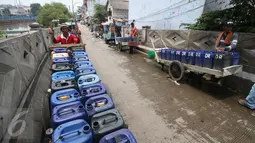 Penjual air memarkir gerobaknya untuk mengisi air bersih di Jakarta, Rabu (30/11). Air yang dijual 10 ribu per dirigen tersebut banyak dibutuhkan warga di pesisir Jakarta dikarenakan sulitnya mendapatkan air bersih. (Liputan6.com/Angga Yuniar)