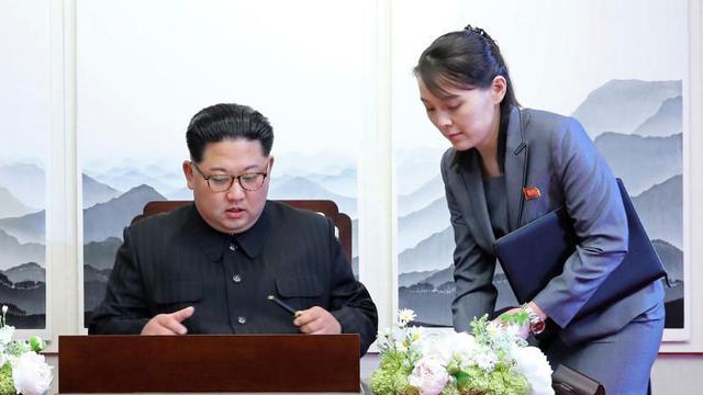 Kim Jong-un sedang menandatangani sebuah buku tamu dengan didampingi adiknya Kim Yo-jong.