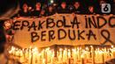 Massa yang tergabung dalam Ultras Garuda Jakarta menggelar aksi seribu lilin dan tabur bunga untuk korban kerusuhan Stadion Kanjuruhan Malang di depan Stadion Gelora Bung Karno (GBK), Jakarta, Minggu (2/10/2022). Aksi yang diikuti ratusan pecinta sepakbola di Jakarta tersebut sebagai bentuk belasungkawa terhadap ratusan korban yang tewas dalam kerusuhan di Stadion Kanjuruhan Malang kemarin. (merdeka.com/Iqbal S Nugroho)