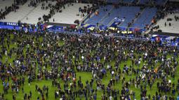 Para penonton ditahan di dalam stadion untuk menghindari serangan bom dan juga kelompok bersenjata di Stadion Stade de France, Prancis, Sabtu (13/11/2015). (AFP Photo/Franck Fife)