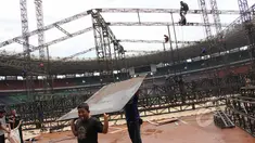 Pekerja membongkar penutup rumput (grass cover) usai konser One Direction di Stadion Utama Gelora Bung Karno (SUGBK), Jakarta, Kamis (26/3/2015). Lapangan SUGBK akan dipersiapkan untuk Pra-Piala Asia U-23. (Liputan6.com/Helmi Afandi)