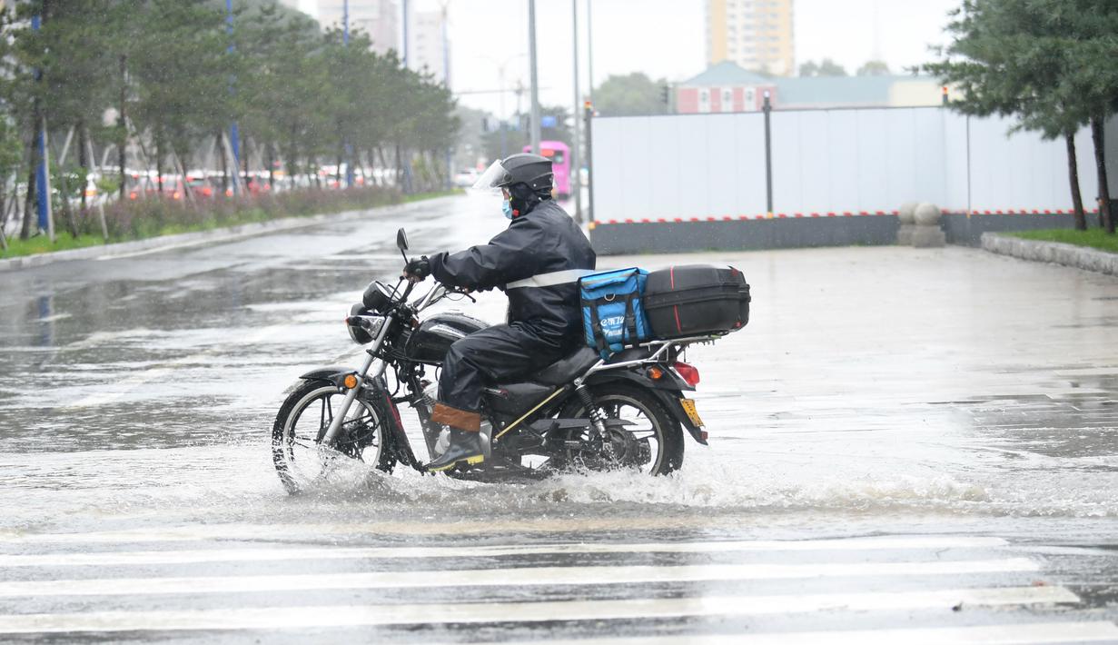 Pengendara motor menerjang genangan usai hujan deras akibat Topan Haishen di Changchun, Provinsi Jilin, China, 8 September 2020. Hujan deras yang dipicu Topan Haishen diperkirakan terjadi di sejumlah besar kawasan China timur laut selama dua hari ke depan. (Xinhua/Yan Linyun)