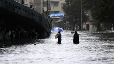 Orang-orang menyeberang jalan melintasi banjir saat hujan lebat di Mumbai, India, Rabu, (5/8/2020). Musim hujan India berlangsung dari Juni hingga September. (AP Photo/Rajanish Kakade)