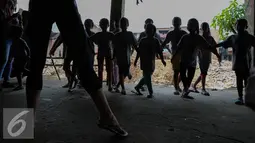 Anak-anak Ciliwung mengikuti gerakan balet saat berlatih di Bantaran Kali Ciliwung, Jakarta, Sabtu (29/8/2015). Pelatihan menari balet ini adalah kerjasama antara Kedubes Australia dengan Yayasan Bina Ballet Indonesia. (Liputan6.com/Faizal Fanani)