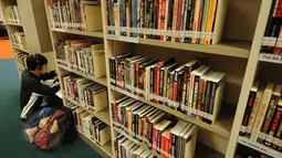 Untuk menambah wawasan tentang dunia olahraga, sebuah perpustakaan ‘Sport Library’ disediakan di areal National Stadium Singapura. Tampak, seorang pengunjung asyik membaca buku di Sport Library, Senin (1/6/2015). (Liputan6.com/Helmi Fithriansyah)