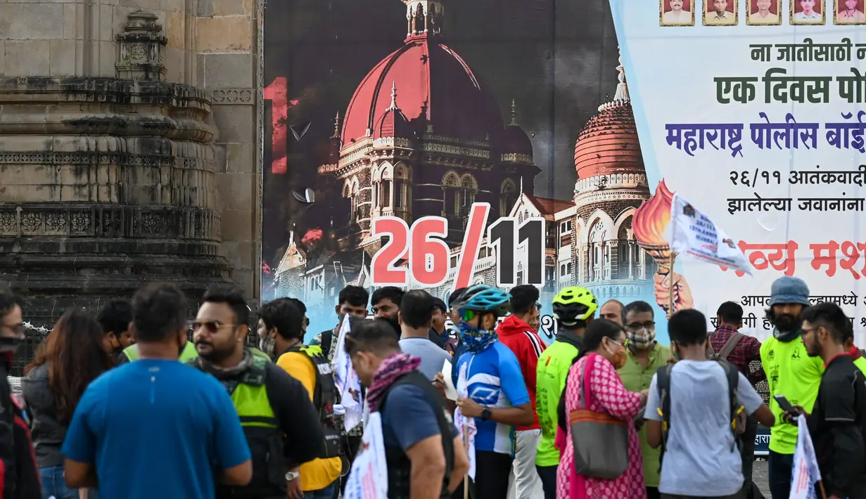 Orang-orang berkumpul di dekat Gerbang India untuk memberikan penghormatan kepada para korban serangan teroris 2008 pada peringatan 13 tahun di Mumbai (26/11/2021). Dalam peringatan itu mereka akan menggelar doa, peletakan karangan bunga, dan melakukan aksi damai. (AFP/Punit Paranjpe)