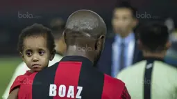 Kapten Persipura, Boaz Solossa, menggendong sang putri sebelum bertanding melawan Bhayangkara FC pada laga Liga 1 Indonesia di Stadion Patriot, Bekasi, Sabtu (9/9/2017). Bhayangkara FC menang 2-1 atas Persipura. (Bola.com/Vitalis Yogi Trisna)