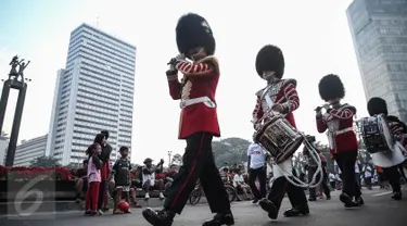 Scotts Guard alias penjaga Buckingham Palace melakukan aksi mengelilingi di Bundaran HI, Jakarta, Minggu (5/6). Aksi Scotts Guard yang didatangkan dari Inggris ini dalam rangka hari ulang tahun Ratu Elizabeth II yang ke-90. (Liputan6.com/Faizal Fanani)