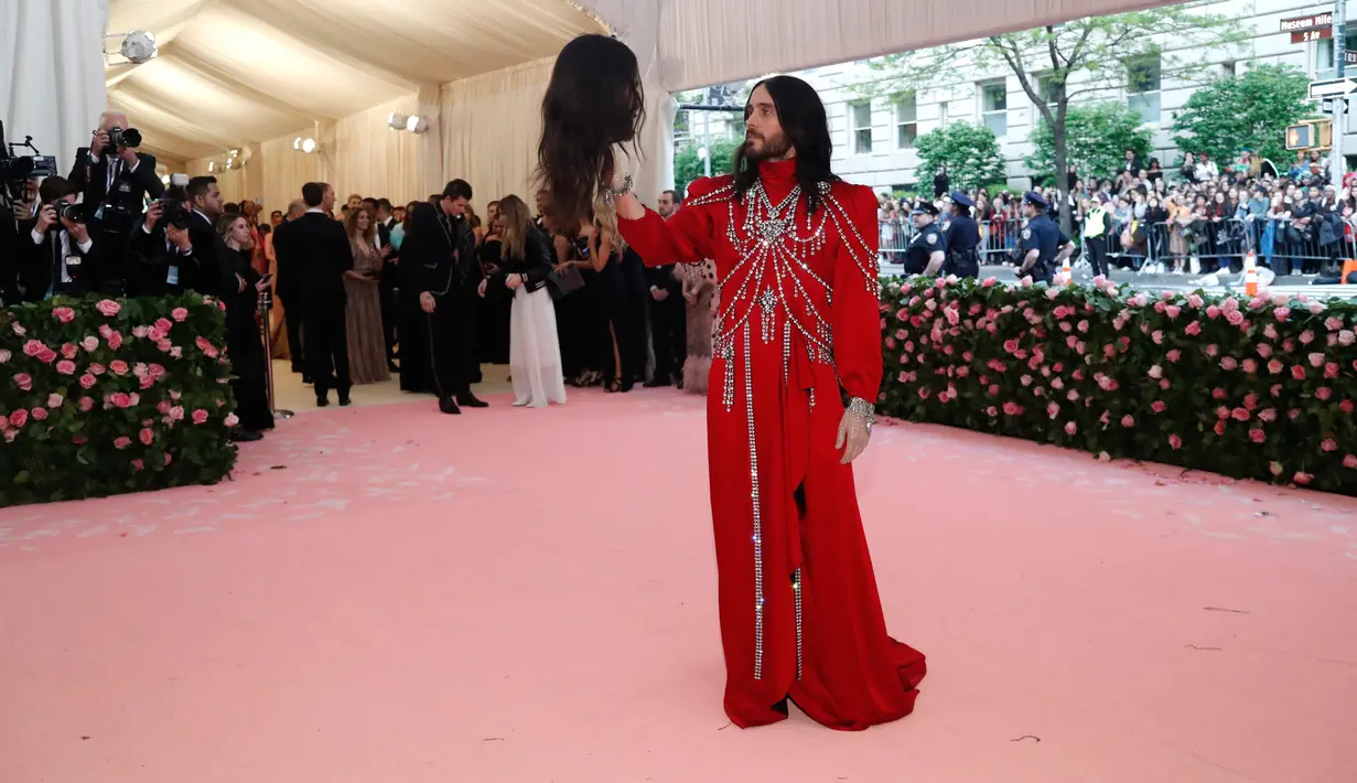 Jared Leto memegang replika potongan kepalanya sendiri saat menghadiri pergelaran Met Gala di Metropolitan Museum of Art New York, AS, Senin (6/5/2019). Jared Leto tampil seperti seorang pangeran dalam balutan busana merah berbentuk dress dengan turtleneck. (REUTERS/Mario Anzuoni)