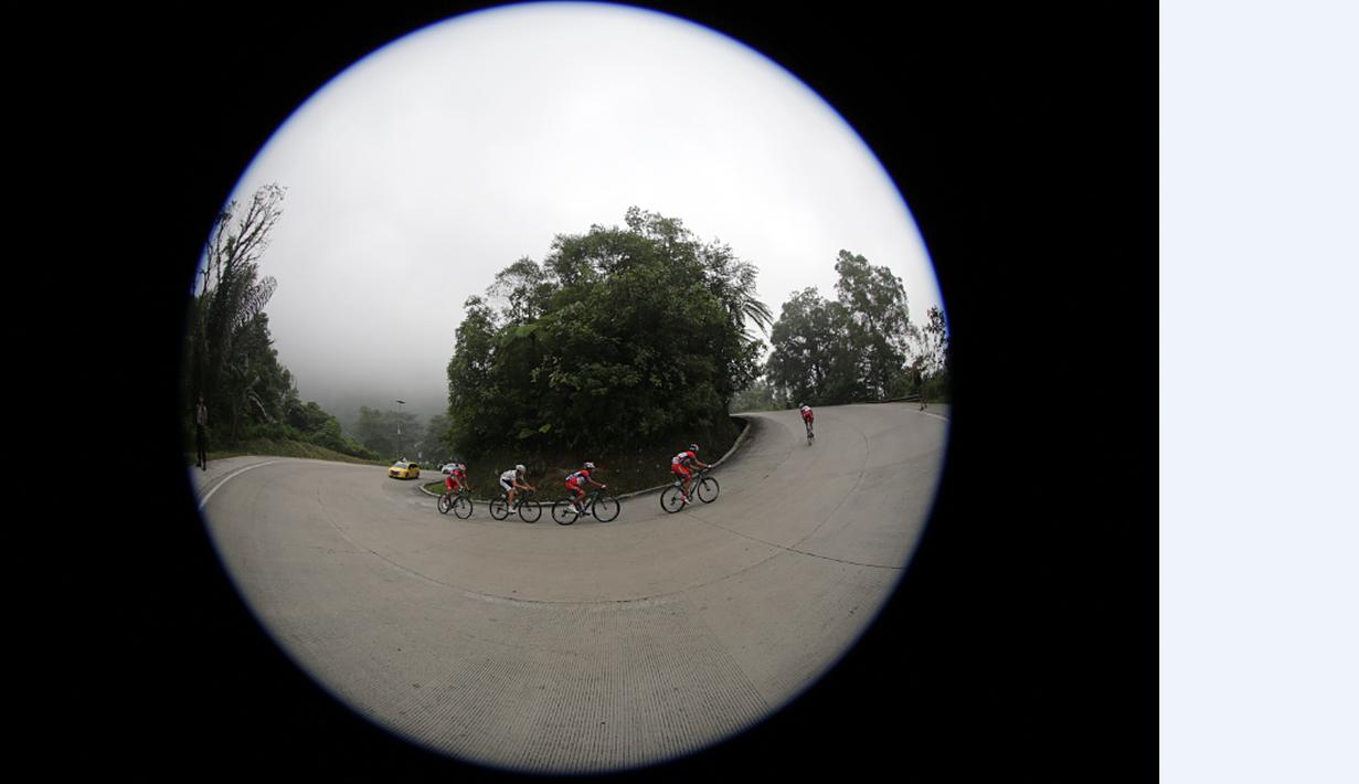 Pebalap sepeda berlomba melewati sebuah tikungan di tanjakan Panorama dalam Etape 2 Tour de Singkarak 2015 dari Padang Pariaman menuju Solok, Sumatra Barat, Minggu (4/10/2015). (Bola.com/Arief Bagus)