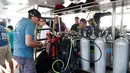 Penyelam memeriksa tangki oksigen saat bersiap melanjutkan pencarian korban kapal wisata yang terbalik di dermaga Chalong, Phuket, Sabtu (7/7). Penyelamat Thailand relah menarik 37 mayat dari perairan setelah kapal wisata tenggelam laut (AP/Vincent Thian)