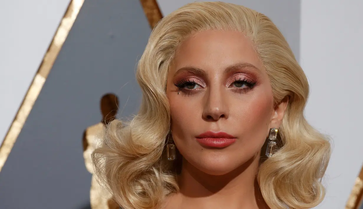 Penyanyi Lady Gaga mengenakan perhiasan dari Lorraine Schwartz di red carpet Piala Oscar 2016. Anting berlian di telinga tunangan aktor Taylor Kinney itu adalah perhiasan dengan harga sekitar Rp 107 miliar. (REUTERS/Adrees Latif )