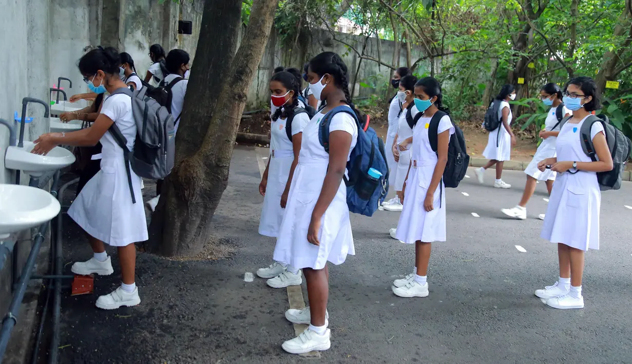 Para siswa yang mengenakan masker berbaris untuk mencuci tangan di sebuah sekolah di Kolombo, Sri Lanka, Senin (6/7/2020). Mulai 6 Juli 2020, siswa kelas 5, 11, dan 13 di Sri Lanka kembali melanjutkan kegiatan belajar. (Xinhua/Ajith Perera)