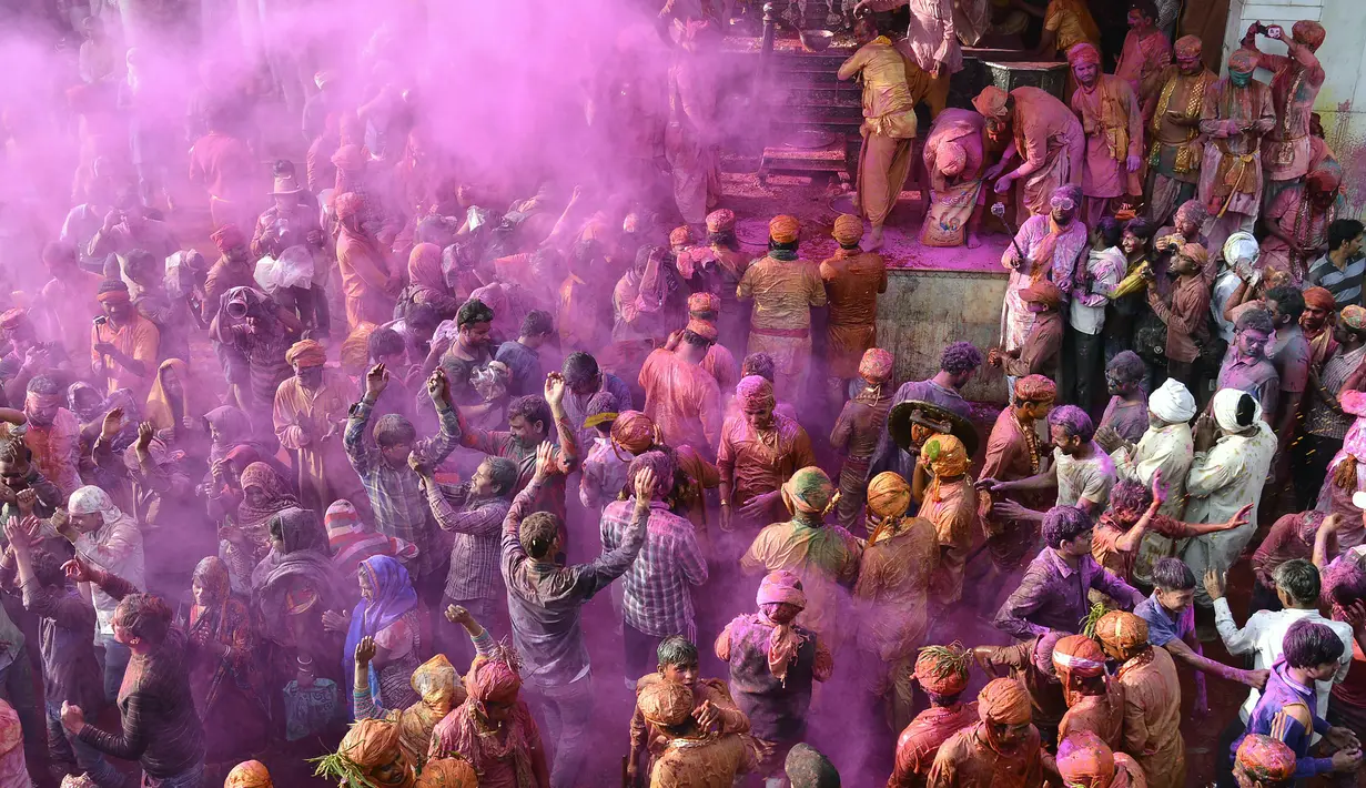 Sejumlah warga India yang tubuhnya berlumuran warna mengikuti festival Holi di desa Nandgaon di negara bagian Uttar Pradesh, India (7/3). Kota-kota tersebut ramai didatangi wisatawan selama musim festival Holi yang berlangsung hingga 16 hari. (AFP)