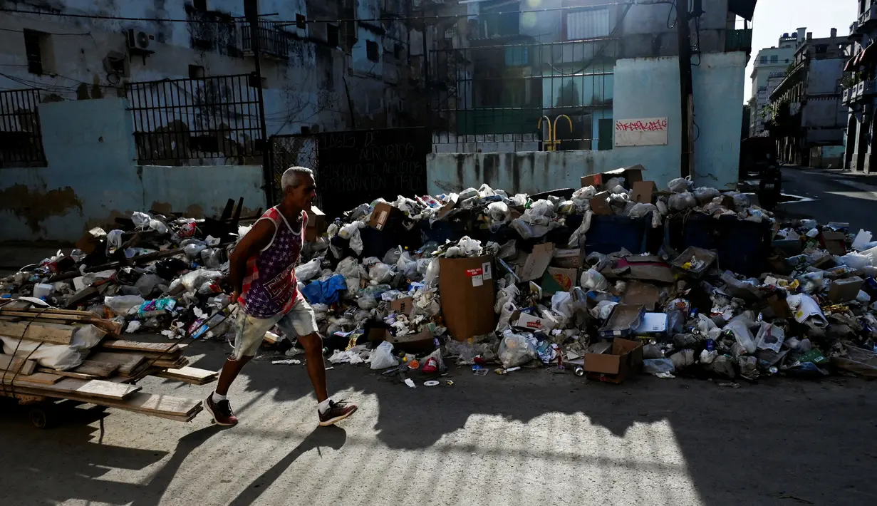 Penyebabnya karena kekurangan bahan bakar dan suku cadang kendaraan yang berdampak pada pengumpulan sampah di pulau yang lumpuh akibat sanksi dan kesengsaraan ekonomi. (YAMIL LAGE / AFP)