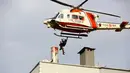 Helikopter Penjaga Pantai menyelamatkan warga yang terdampar di atap gedung setelah banjir memaksa orang untuk mencari keselamatan di tempat yang tinggi dan tanah longsor, di kota Bozkurt provinsi Kastamonu, Kamis (12/8/2021). Musibah tersebut menewaskan lima orang. (IHA via AP)