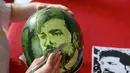 Seorang siswa sekolah menengah mengukir wajah pemain sepak bola Mesir, Mohamed Salah pada buah semangka di Shenyang, Provinsi Liaoning, China, Senin (9/7). (AFP)