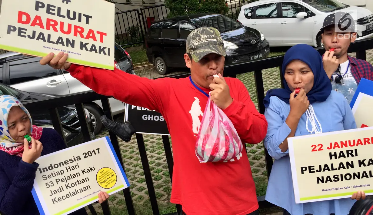Aktivis Koalisi Pejalan Kaki meniup peluit dan membawa sejumlah poster saat menabur bunga di sekitar Halte Tugu Tani, Jakarta, Senin (22/1). (Liputan6.com/Immanuel Antonius)