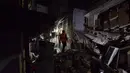 Petugas pemdam kebakaran memeriksa tempat kejadian setelah dugaan ledakan gas di jalanan ramai di Moghbazar, Dhaka, Bangladesh, Minggu (27/6/2021). Tayangan televisi memperlihatkan pilar-pilar yang rubuh, beton pecah dan pecahan kaca berserakan di seberang jalan. (Munir Uz zaman/AFP)