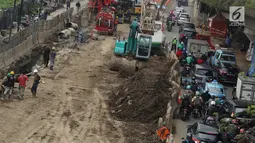 Kendaraan melintas di samping proyek pembangunan terowongan bawah tanah (underpass) Simpang Matraman, Jakarta, Rabu (19/7). Rekayasa lalu lintas terkait pembangunan underpass di kawasan itu akan diuji coba pada 20-27 Juli. (Liputan6.com/Immanuel Antonius)