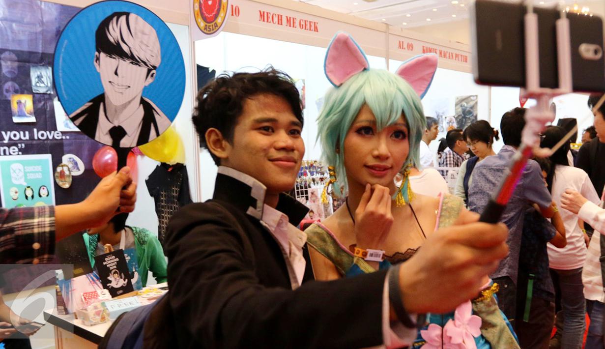 Dua orang cosplay sedang selfie pada gelaran Popcon Asia 2016 di Jakarta Convention Center (JCC), Jakarta (14/08). Festival yang berlangsung 12-14 Agustus diikuti 225 booth pegiat kreatif tanah air. (Liputan6.com/Fery Pradolo)