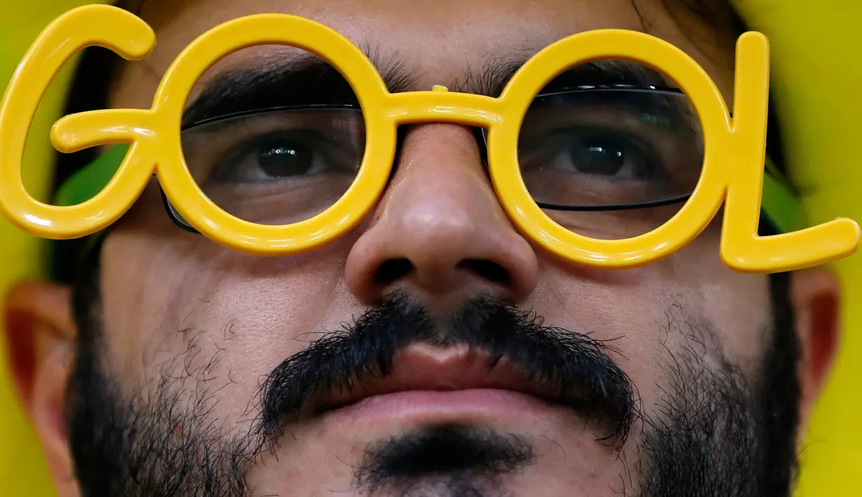 Suporter Brasil menggunakan kacamata unik menunggu dimulainya laga terakhir penyisihan grup E Piala Dunia 2018 melawan Serbia di Stadion Spartak, Rusia, Rabu (27/6). Brasil sukses melaju ke babak 16 besar usai menang 2-0. (AP Photo/Matthias Schrader)