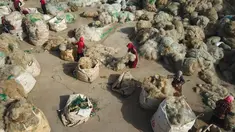 Para nelayan membersihkan jaring ikan yang dibuang untuk didaur ulang di sebuah desa di Lianyungang, di provinsi Jiangsu timur China (17/3/2021). Daur ulang jaring ikan tersebut akan dibuat palet nilon. (STR/AFP/China Out)