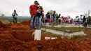 Kerabat menangis di dekat makam korban tanah longsor di Mocoa, Kolombia, (3/4). Musibah ini memakan korban jiwa hingga ratusan orang dan menghancurkan seluruh lingkungan. (AP Photo / Fernando Vergara)