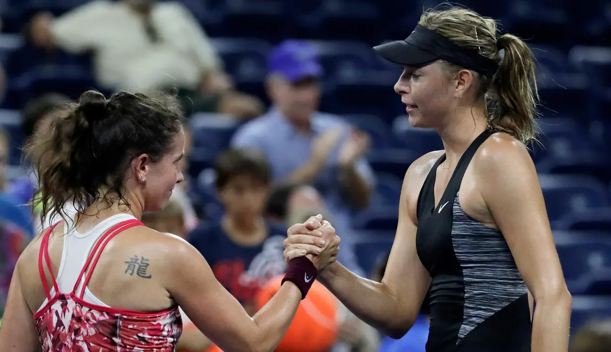 Petenis Rusia, Maria Sharapova berjabat tangan dengan Patty Schnyder dari Swiss usai pertandingan tunggal pertama putri AS Terbuka 2018 di New York, (28/8). Sharapova tampil sengit melawan petenis berusia 39 tahun tersebut. (AP Photo/Julio Cortez)