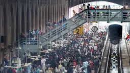Para pelancong menunggu rangkaian kereta saat mudik menuju kampung halaman untuk merayakan Idul Adha di stasiun Lahore, Pakistan, Sabtu (10/8/2019). Umat Islam di seluruh dunia merayakan Idul Adha yang identik dengan tradisi berkurban. (Photo by ARIF ALI / AFP)
