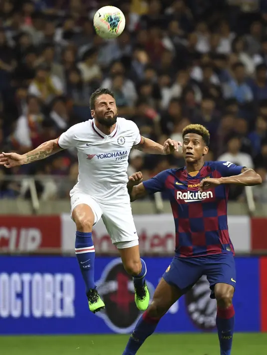 Striker Chelsea, Olivier Giroud berebut bola udara dengan bek Barcelona Jean-Clair Todibo  selama pertandingan laga perdana pramusim di Saitama Stadium 2002, Saitama, Selasa (23/7/2019). Chelsea menang tipis 2-1 atas Barcelona. (AFP Photo/Toshifumi Kitamura)