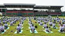 Ratusan warga melakukan gerakan yoga saat mengikuti yoga massal di Stadion Afraha, Nakuru, Kenya (15/6/2019). Hari Yoga Internasional, yang setiap tahun dirayakan pada 21 Juni, pertama kali diusulkan Perdana Menteri India Narendra Modi pada 2014 ke Majelis Umum PBB. (AFP Photo/Suleiman Mbatiah)