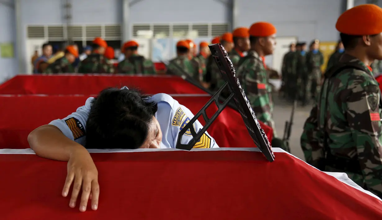 Seorang anggota Wara memeluk peti mati suaminya yang menjadi korban dari jatuhnya pesawat Hercules C-130 di Medan, Rabu (1/7/2015). Peristiwa ini menambah catatan kecelakaan yang disebabkan tuanya alustista yang digunakan TNI. (REUTERS/Beawiharta)