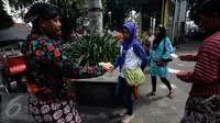 Warga melintas saat sosialisasi pilkada bebas uang politik oleh Panwas Kota Yogyakarta di kawasan Titik Nol Kilometer, Senin (1/8). Kegiatan tersebut untuk mensosialisasikan pelaksanaan pilkada serentak 2017 mendatang. (Liputan6.com/Boy Harjanto)