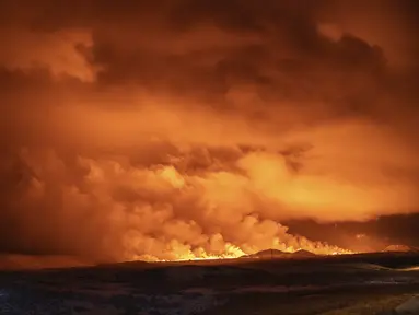 Langit malam diterangi cahaya akibat letusan gunung berapi di Grindavik di Semenanjung Reykjanes Islandia, Senin (18/12/2023). (AP Photo/Marco Di Marco)