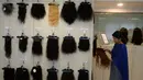 Pekerja memajang rambut palsu yang siap dijual di display centre Raj Hair International, Chennai, India (25/7). (AFP Photo/Arun Sankar)
