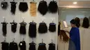Pekerja memajang rambut palsu yang siap dijual di display centre Raj Hair International, Chennai, India (25/7). (AFP Photo/Arun Sankar)